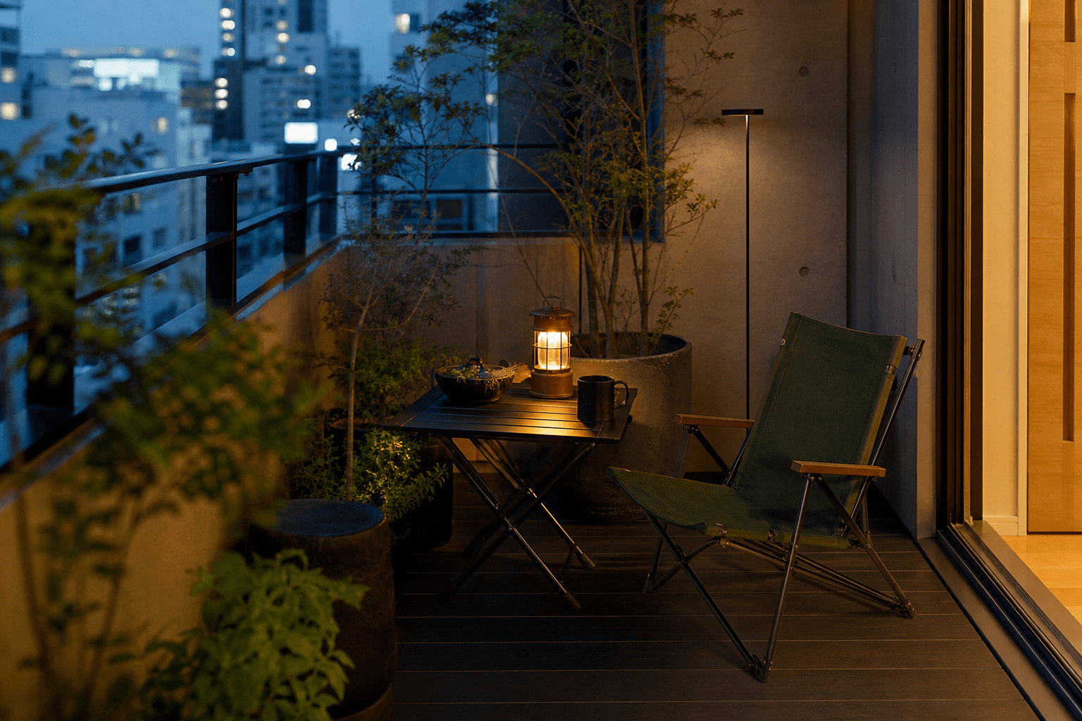 Compact balcony ritual with foldable chair, table, lantern, and accent light at blue hour